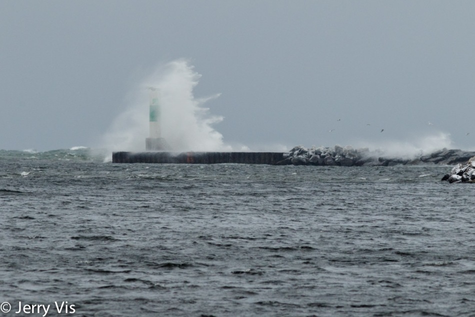 A wave crashing over the harbor light at Muskegon